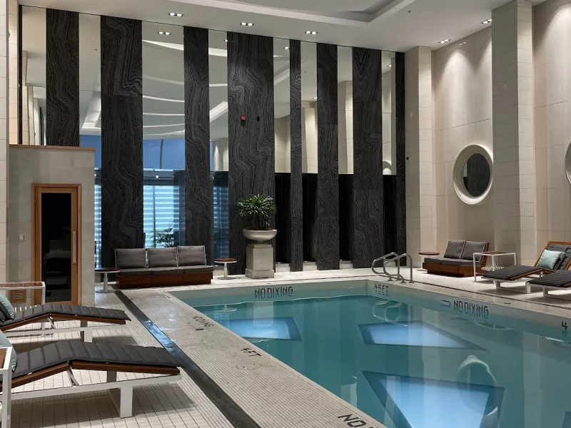 Indoor spa pool with loungers, tiled deck, and modern wellness design