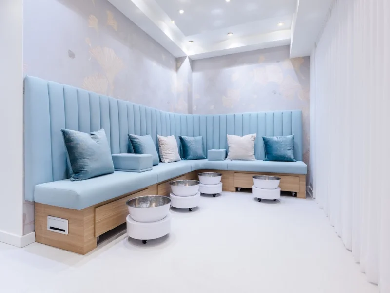 Luxury spa lounge with curved blue seating and pedicure bowls