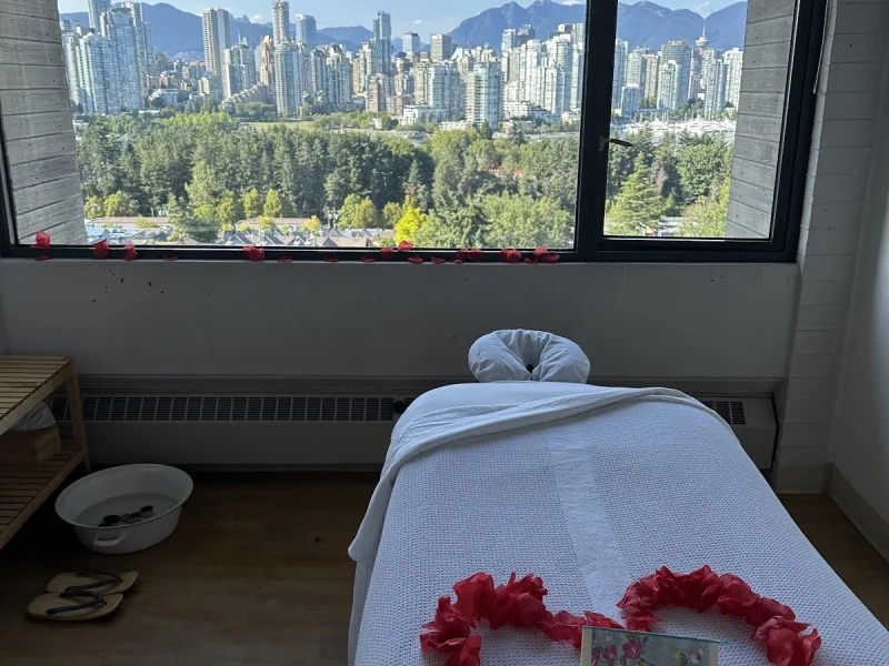Massage treatment room with skyline and mountain views through a large window