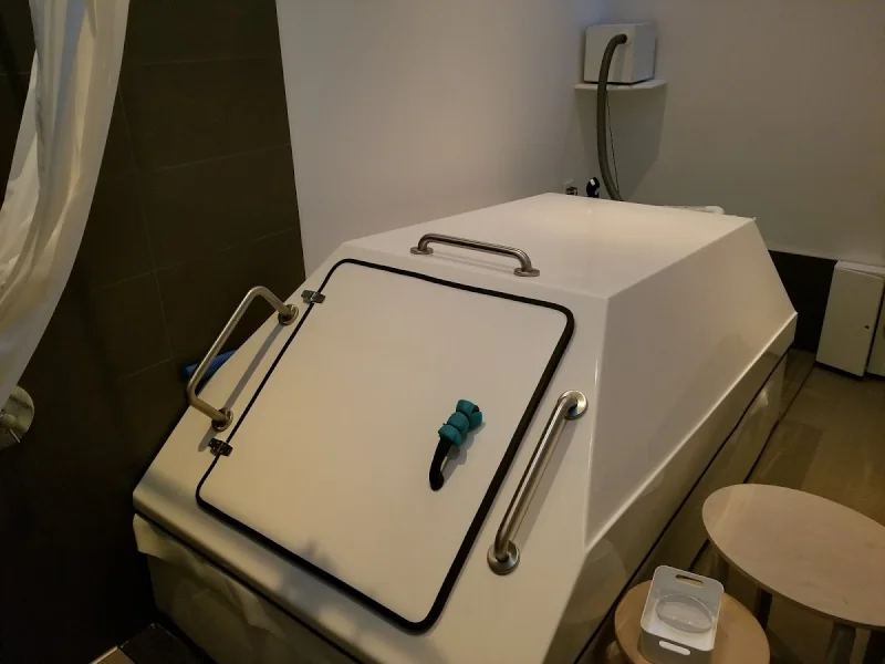 Private float tank room with enclosed pod and calm neutral lighting
