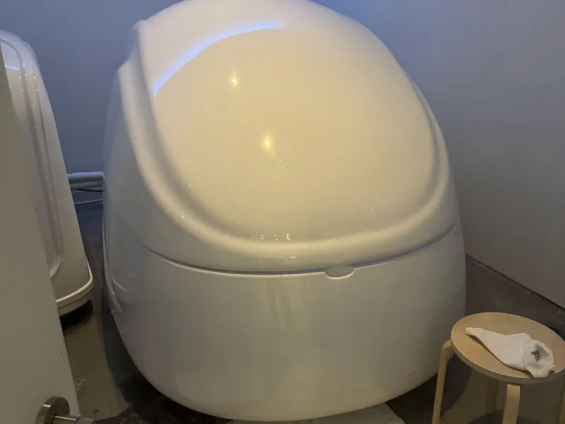 Modern float therapy pod with pale buoyant water and minimalist spa ambiance