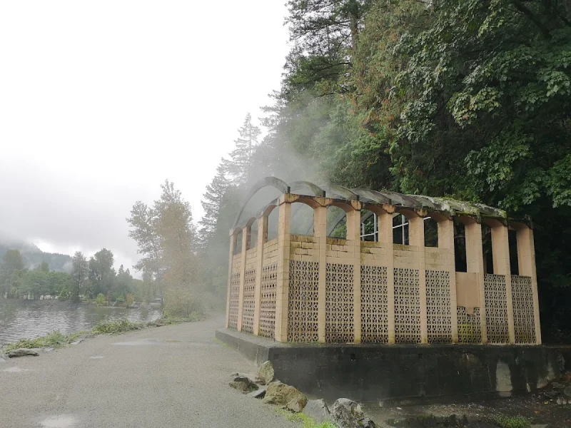 Steam rising from a rustic lakeside hot spring pavilion in Harrison Hot Springs