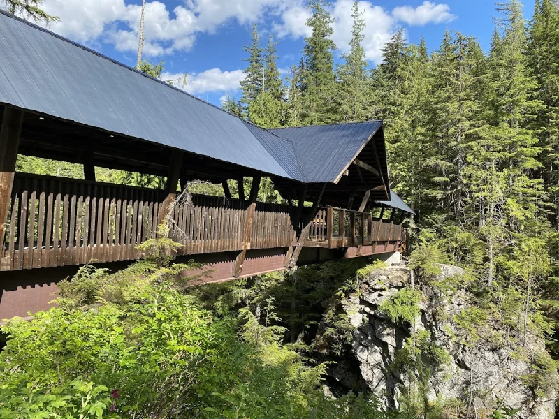 Modern wooden lodge structure perched above canyon landscape with forest surroundings