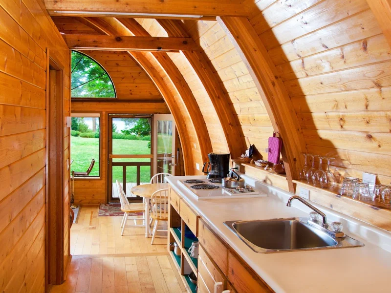 Curved cedar kitchen and dining space in a forest cabin retreat