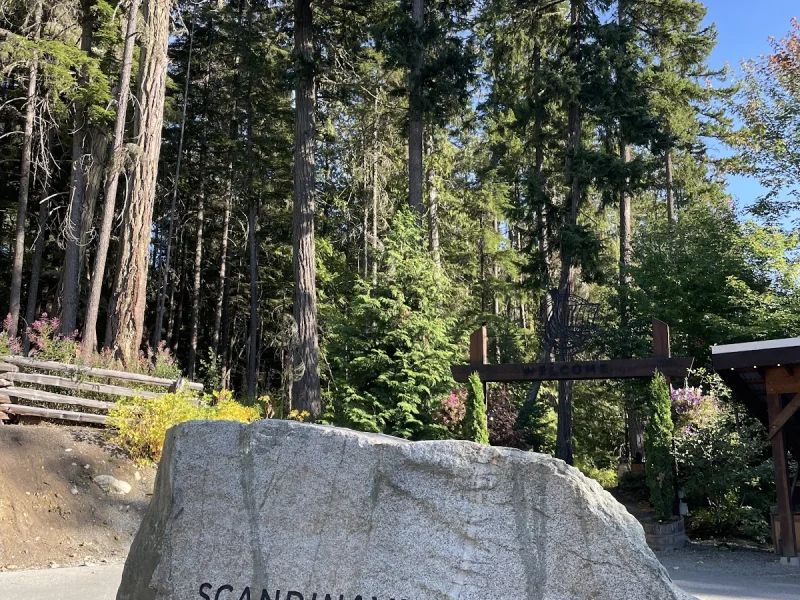 Scandinave Spa Whistler entrance sign framed by tall evergreen forest