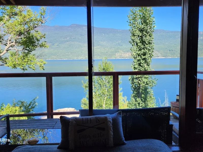 Lakefront deck with mountain views from a cozy guest house interior