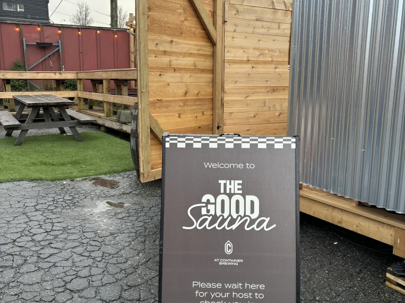 Outdoor entrance to The Good Sauna with signage and rustic deck path