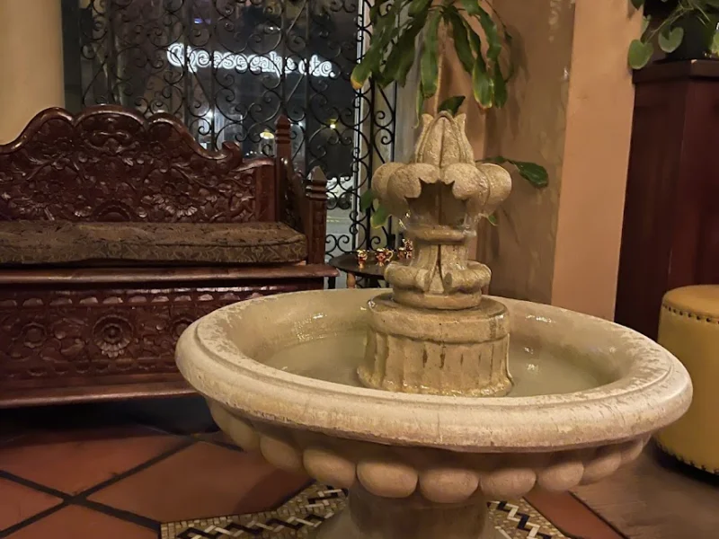 Spa lounge with ornate stone fountain, decorative ironwork, and intimate seating alcoves