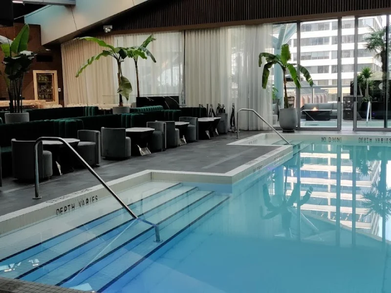 Indoor spa pool with lounge seating, skylight, and city views